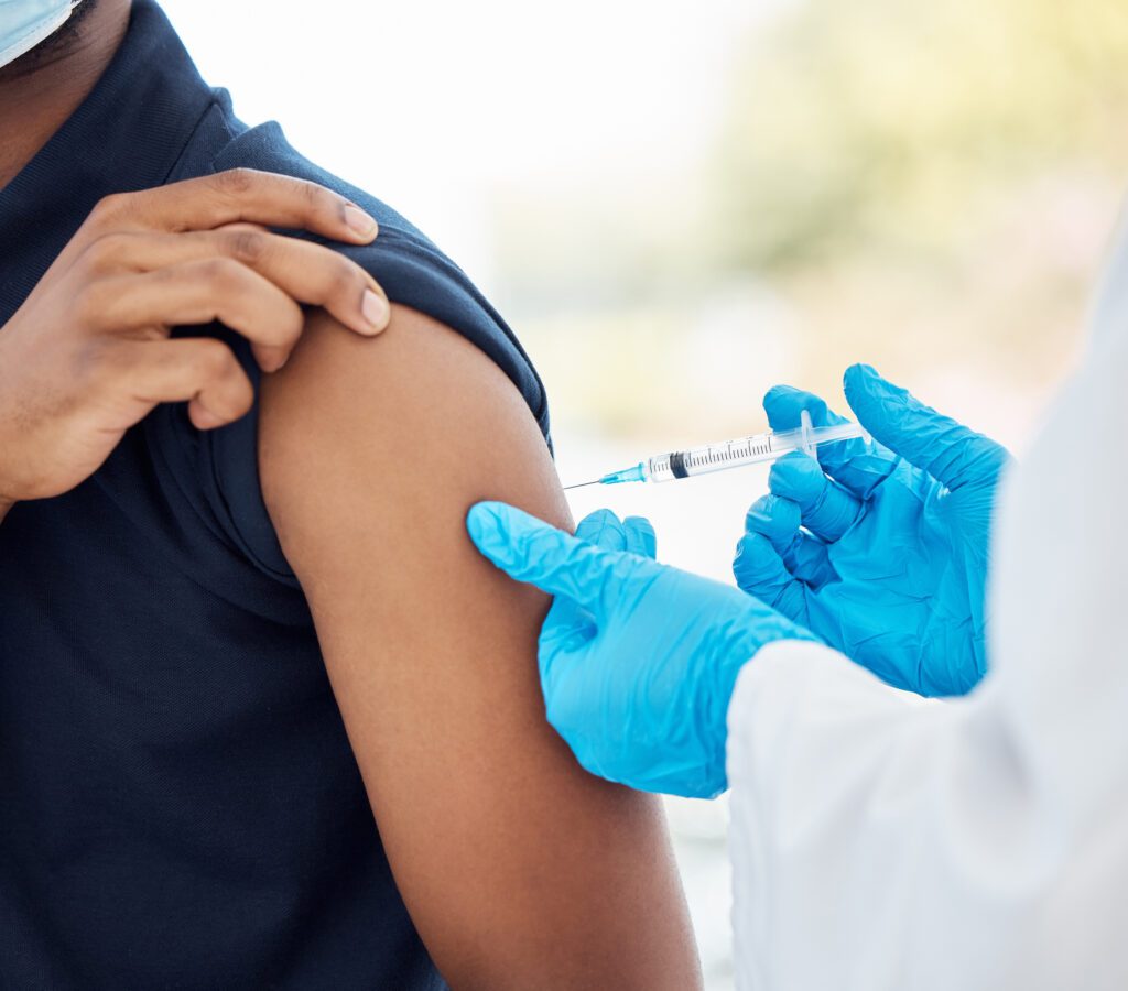 Covid vaccine, healthcare and patient during consultation with doctor for health, wellness and medicine injection in arm. Medical man in hospital for immunization with clean needle for covid 19 shot